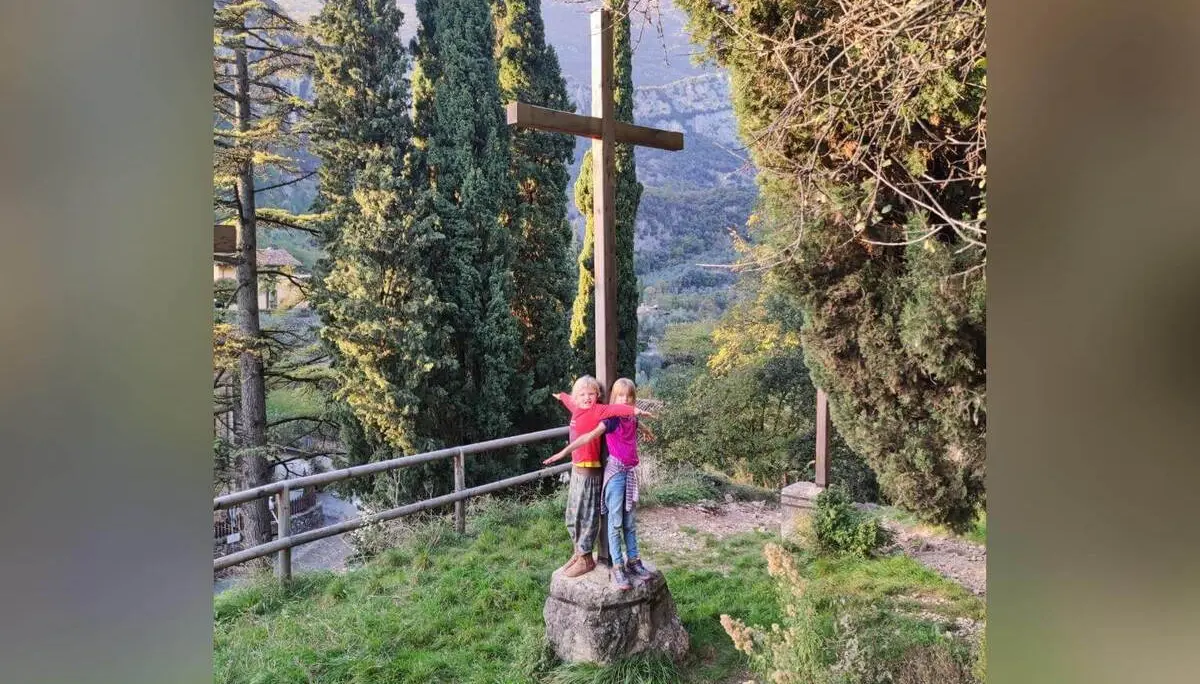 Zwei Kinder mit Helmen und Klettergurten steigen an einer gesicherten Felswand empor, rote Seile verlaufen entlang der Route. | © DAV Markt Schwaben / Silke Titze