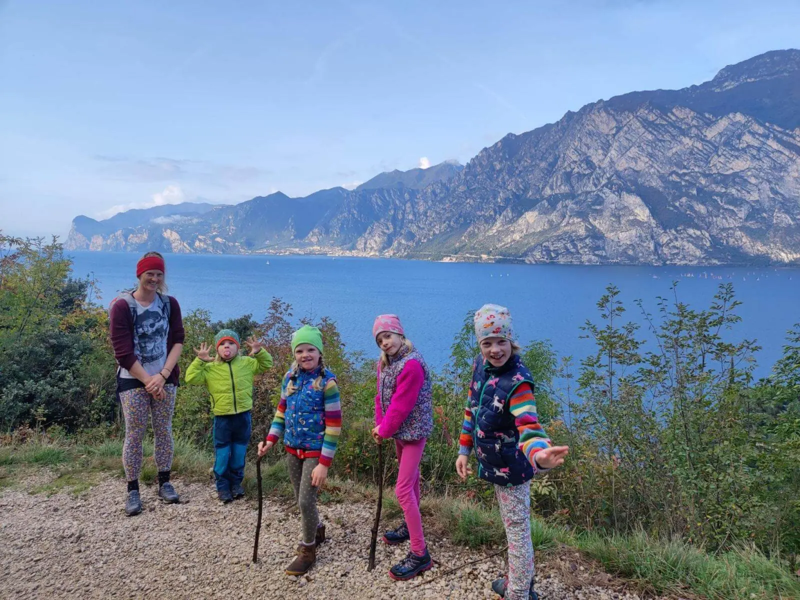 Mehrere Kinder und eine erwachsene Person stehen an einem Aussichtspunkt über dem Gardasee, dahinter erheben sich steile Berge. | © DAV Markt Schwaben / Silke Titze