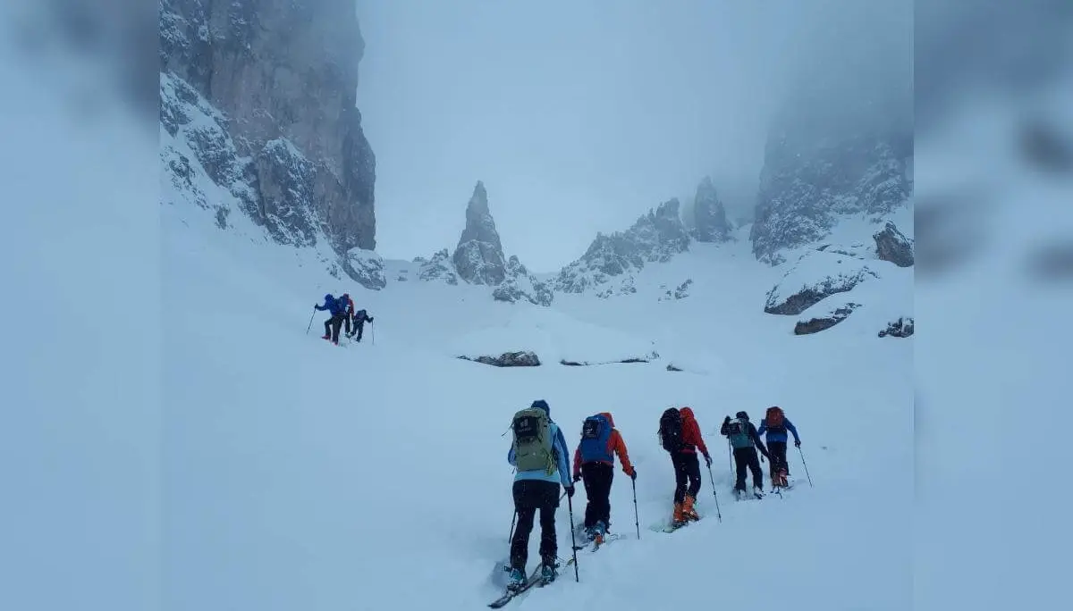 Skitourengruppe steigt bei Nebel und Schneefall durch steiles, felsiges Gelände zur Forcella della Neve auf. | © DAV Markt Schwaben · Foto: Silvia Mack