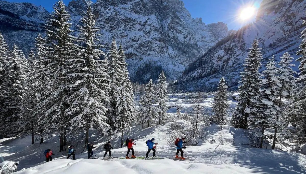   Skitourengruppe steigt bei Sonnenschein durch verschneites Gelände zum Sextner Stoan mit Dolomitenblick im Hintergrund. | © DAV Markt Schwaben · Foto: Peter Langenbacher