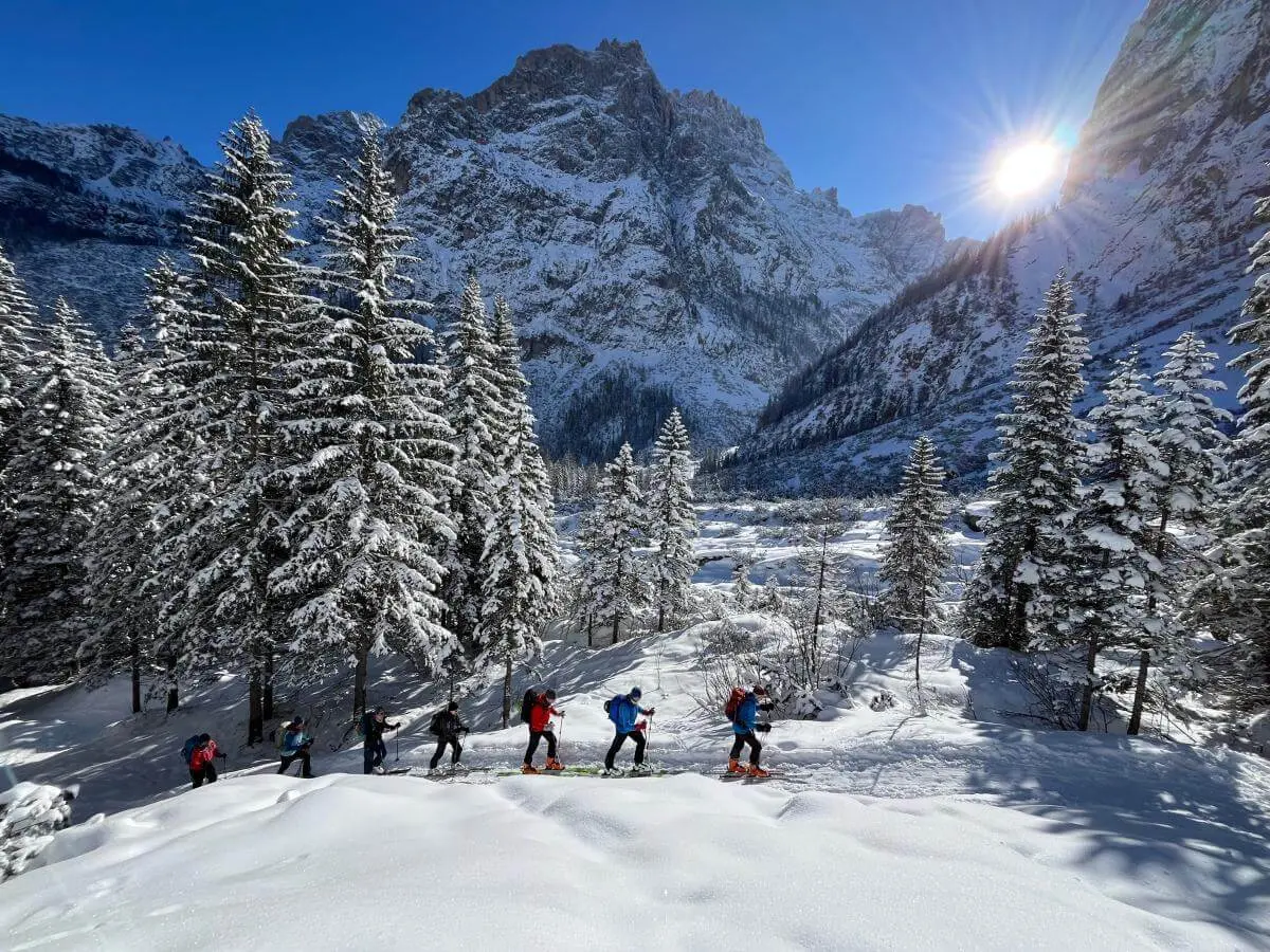   Skitourengruppe steigt bei Sonnenschein durch verschneites Gelände zum Sextner Stoan mit Dolomitenblick im Hintergrund. | © DAV Markt Schwaben · Foto: Peter Langenbacher