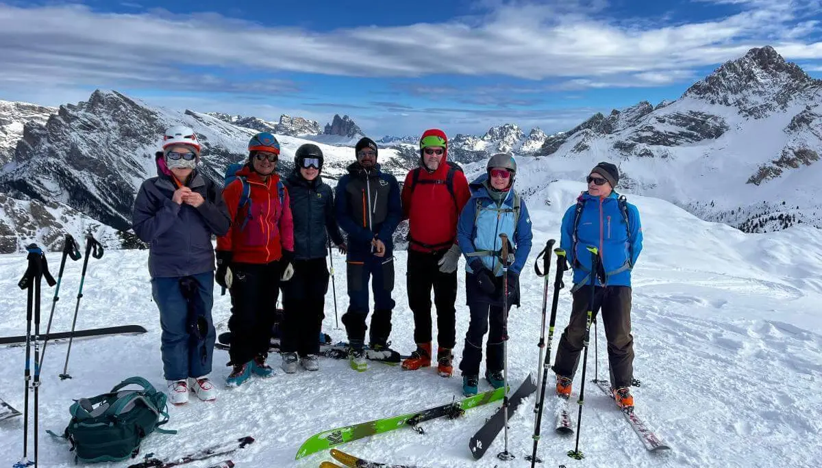Skitourengruppe steht bei Sonnenschein auf verschneitem Plateau vor den markanten Drei Zinnen in den Dolomiten. | © DAV Markt Schwaben · Foto: Markus Sellmeier