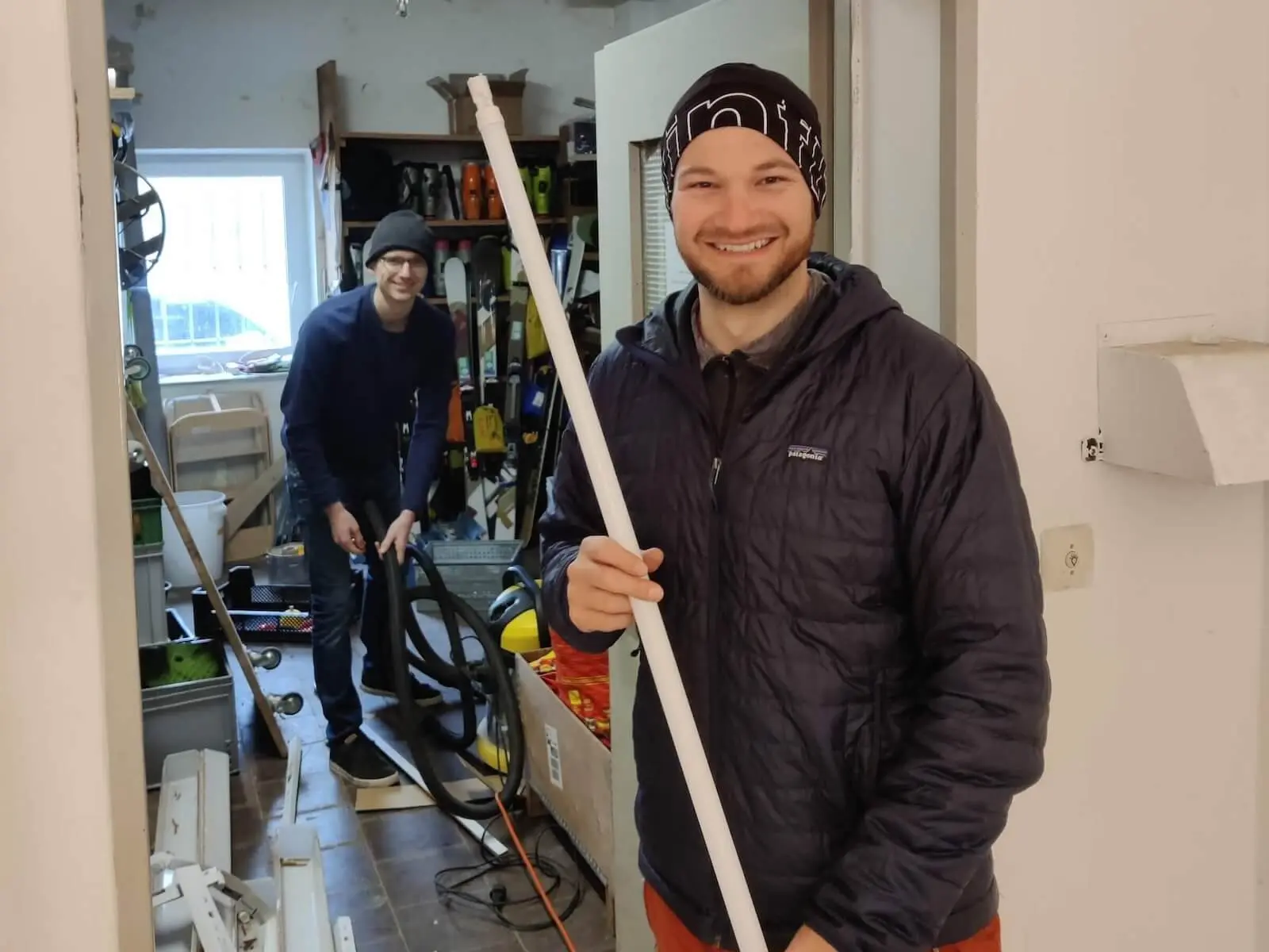 Zwei Personen im Materiallager, die Person im Vordergrund hält eine Leuchtstoffröhre, beide lächeln. | © DAV Markt Schwaben