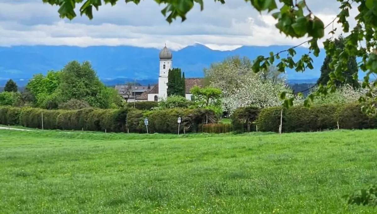 Dorfansicht mit Kirche und Alpenpanorama. | © DAV Markt Schwaben / Hubert Inhofer