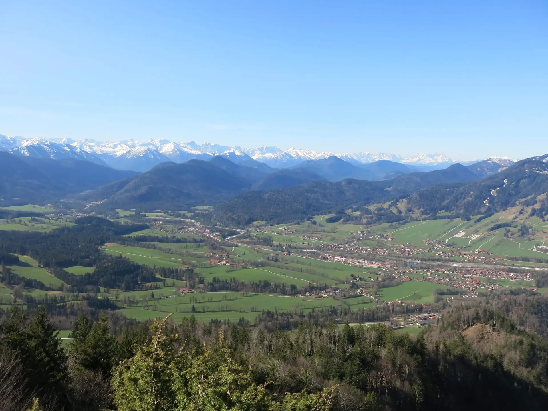 Panoramablick auf ein grünes Tal mit kleinen Dörfern, umgeben von majestätischen, schneebedeckten Bergen unter klarem Himmel – eine malerische und beruhigende Landschaft. | © DAV Markt Schwaben | Foto Erwin Matzinger