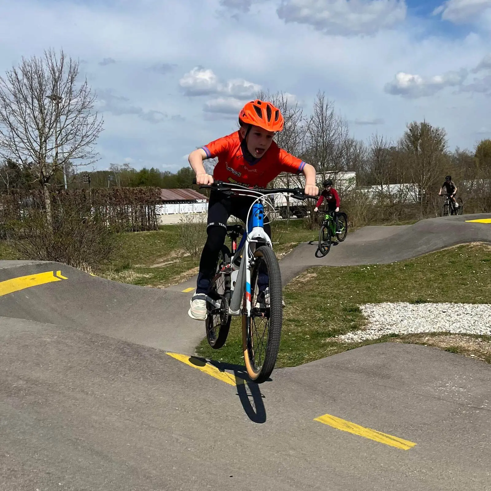 Person in orangem Helm und Shirt springt mit Fahrrad über BMX-Rampe – Action und Techniktraining pur! | © DAV Markt Schwaben | Foto Miron Thoms