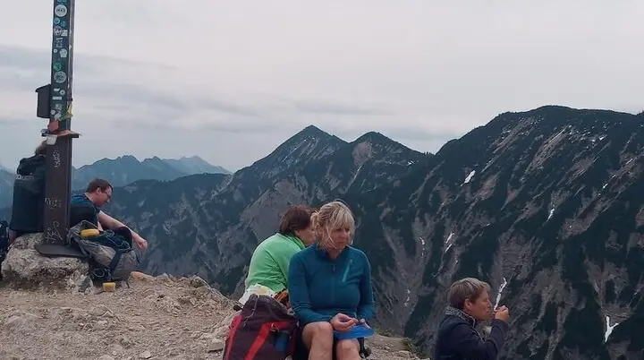 Ein Foto vom Gipfel mit Wanderern, die die atemberaubende Aussicht genießen. | © DAV Markt Schwaben | Foto Tanja Döhler