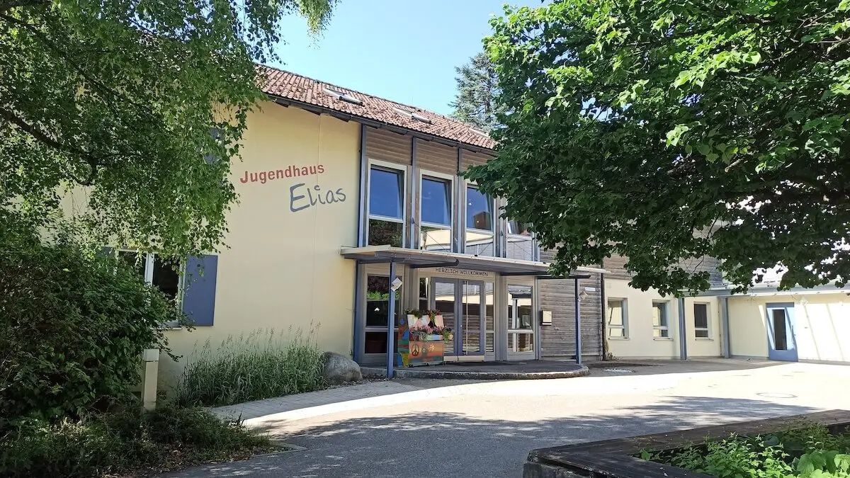 Das Jugendhaus Elias in Seifriedsberg, Ausgangspunkt für Wanderungen im Naturpark Nagelfluhkette, mit Bäumen und Bank davor. | © DAV Markt Schwaben