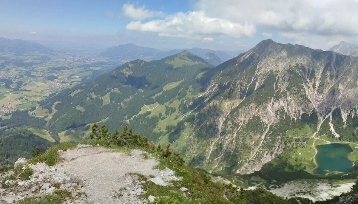 Blick vom Rubihorn über grüne Täler, alpine Seen und felsige Gipfel unter teils bewölktem Himmel – ein Moment voller Weite. | © DAV Markt Schwaben