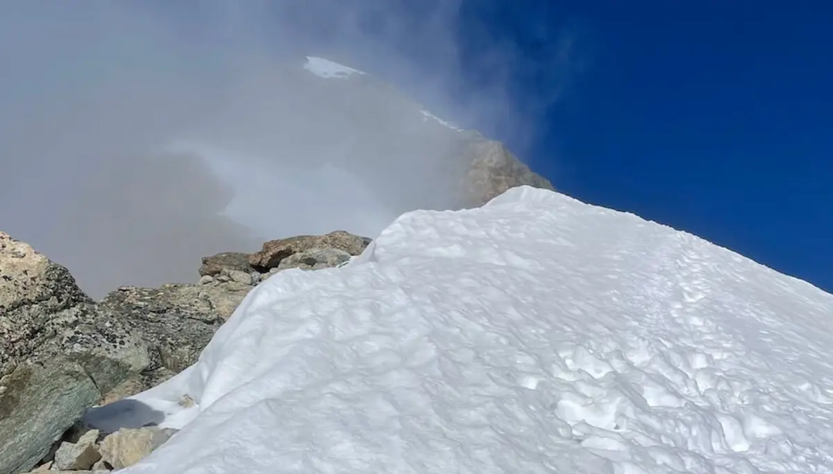 Auf einer schneebedeckten Westalpenflanke führen Fußspuren bergauf – Nebelschwaden verhüllen den Gipfel am Horizont. | © DAV Markt Schwaben | Christian Reischl