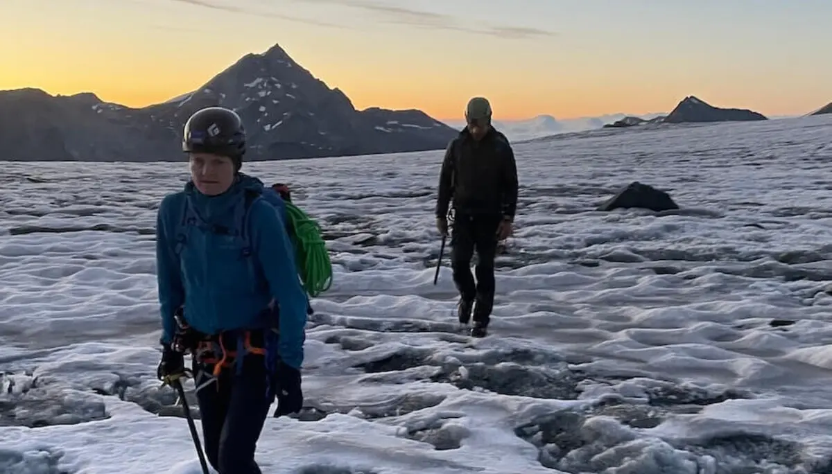 Zwei Bergsteiger durchqueren einen verschneiten Gletscher in den Westalpen bei Sonnenaufgang – Berge und Ausrüstung im Fokus. | © DAV Markt Schwaben | Christian Reischl