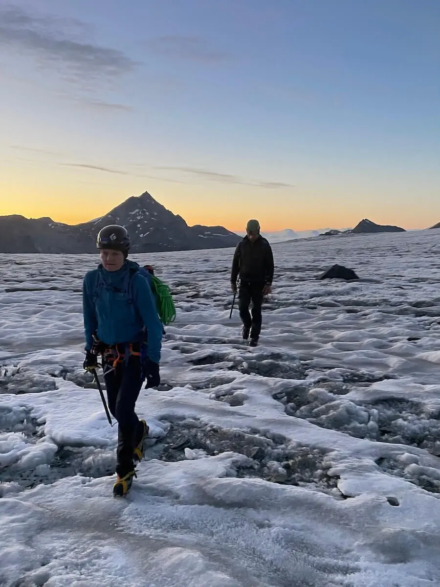 Zwei Bergsteiger durchqueren einen verschneiten Gletscher in den Westalpen bei Sonnenaufgang – Berge und Ausrüstung im Fokus. | © DAV Markt Schwaben | Christian Reischl