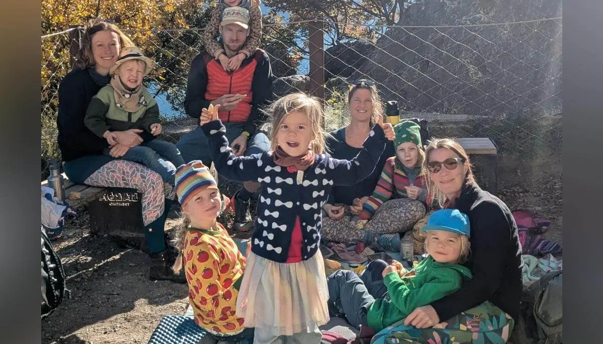 Fünf Kinder sitzen auf einer roten Bank vor einer hellen Wand und essen Eis. Ein Kind hält zusätzlich eine Puppe. Alle tragen bunte Kleidung. | © DAV Markt Schwaben · Foto: Silke Titze