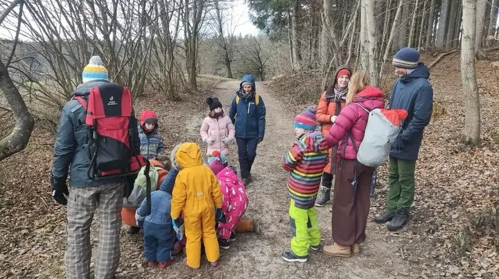 Gruppe von Erwachsenen und Kindern in bunter Winterkleidung auf einem Waldweg bei einem Naturausflug. | © DAV Markt Schwaben Familiengruppe