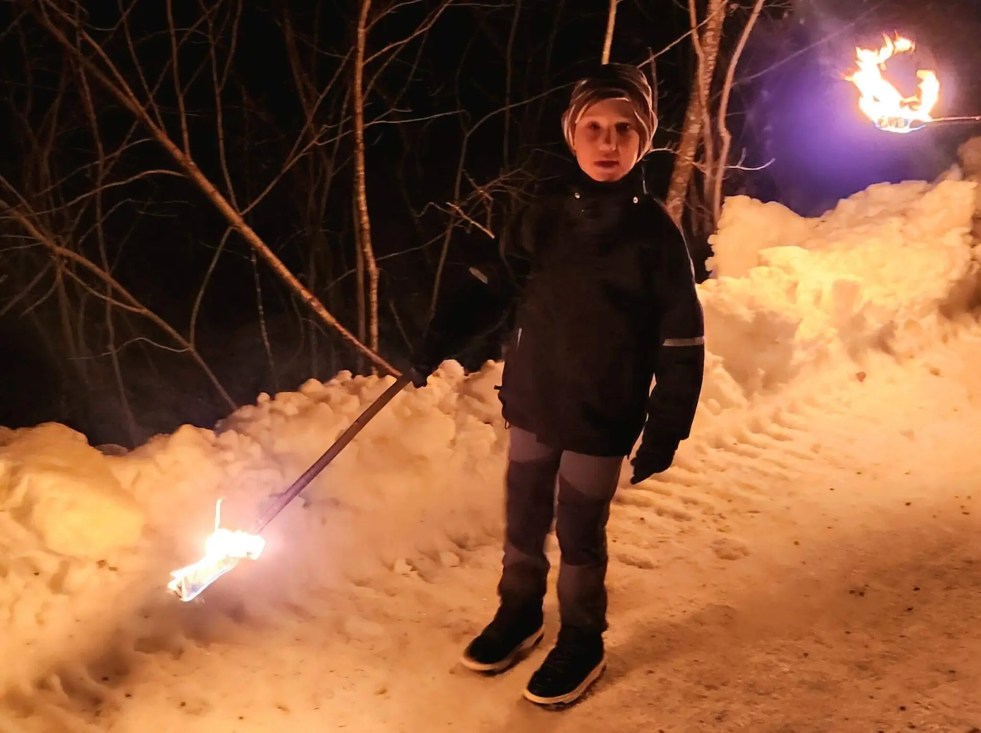 Ein Kind in der dunklen Nacht, warm angezogen, hält eine brennende Fackel. | © DAV Markt Schwaben