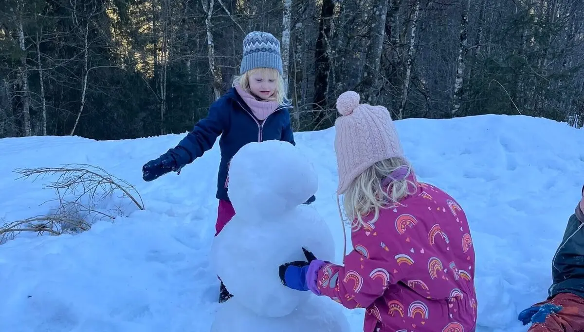 Zwei Mädchen bauen einen Schneemann. Sie sind warm angezogen und konzentriert bei der Arbeit. | © DAV Markt Schwaben