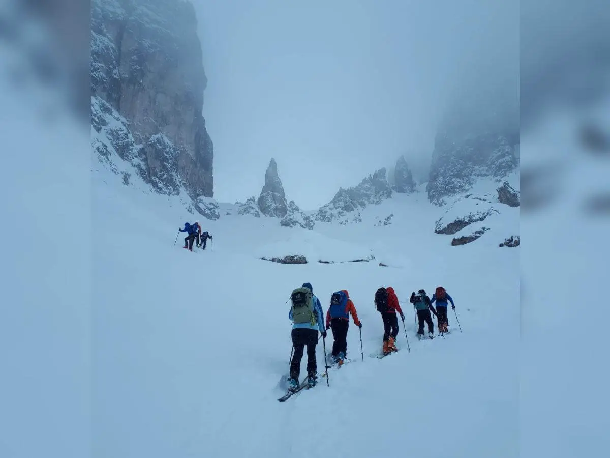 Skitourengruppe steigt bei Nebel und Schneefall durch steiles, felsiges Gelände zur Forcella della Neve auf. | © DAV Markt Schwaben · Foto: Silvia Mack