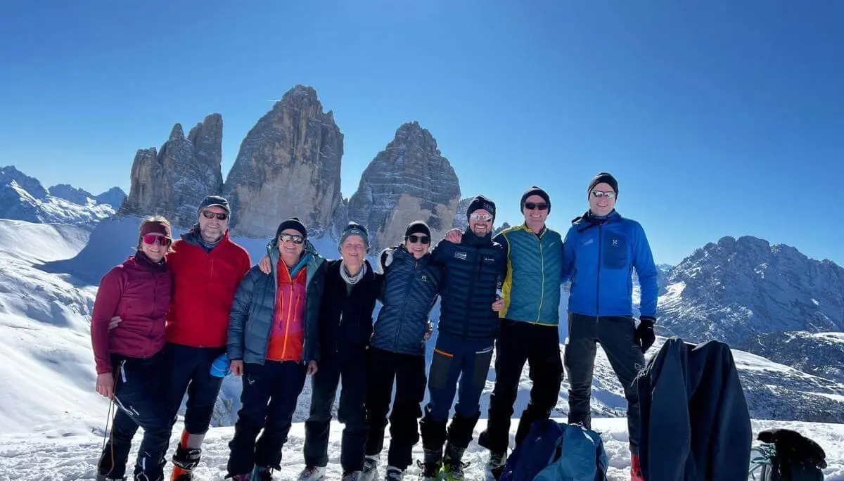 Skitourengruppe steht auf dem Sextner Stoan bei Sonnenschein mit Blick auf die Drei Zinnen im verschneiten Dolomitenpanorama. | © DAV Markt Schwaben · Foto: Markus Sellmeier