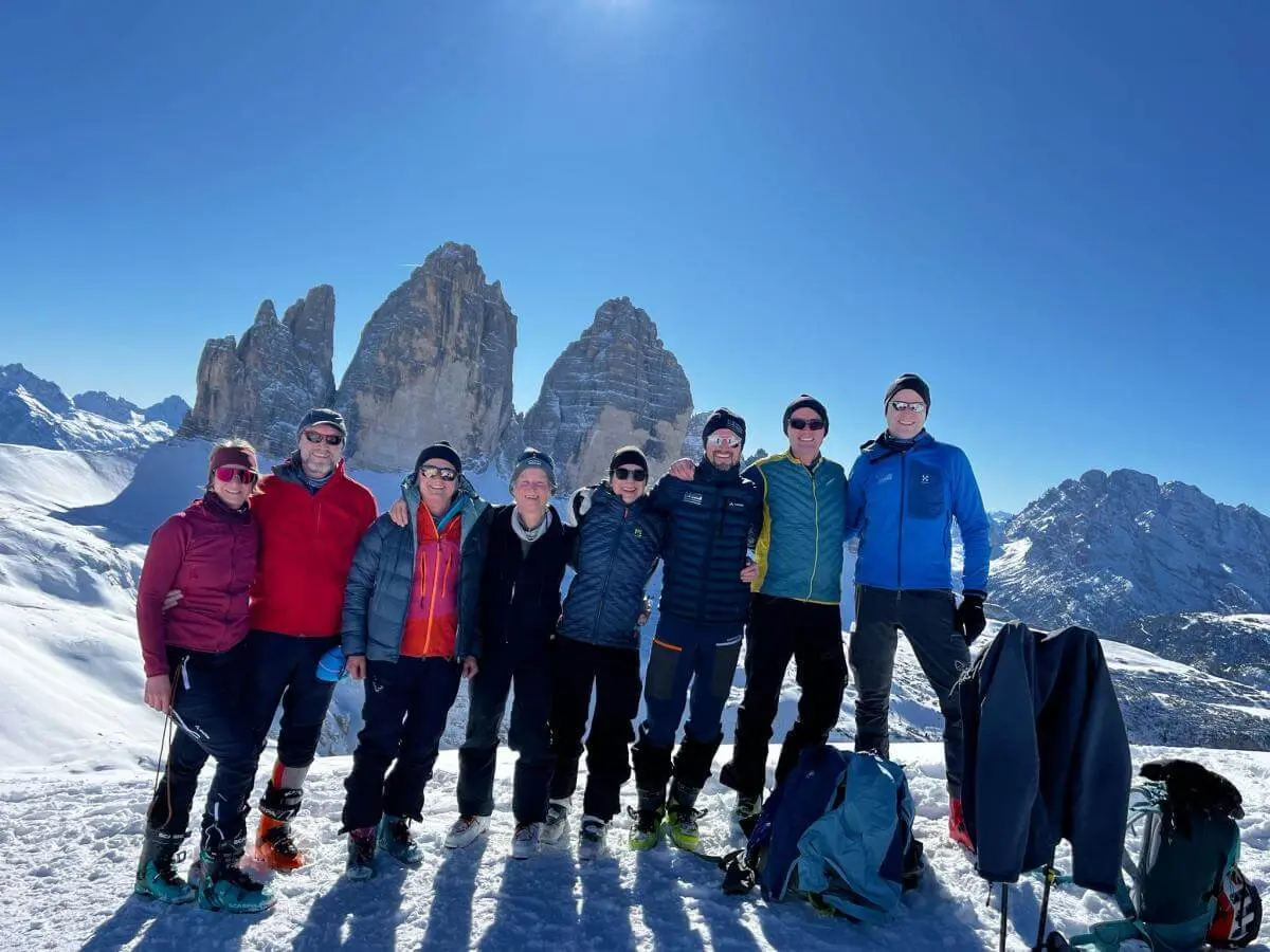 Skitourengruppe steht auf dem Sextner Stoan bei Sonnenschein mit Blick auf die Drei Zinnen im verschneiten Dolomitenpanorama. | © DAV Markt Schwaben · Foto: Markus Sellmeier