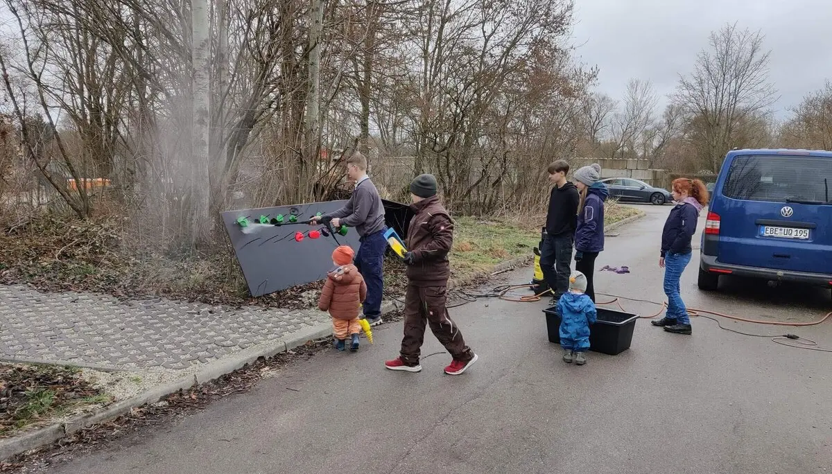 Mitglieder der Sektion stehen draußen, halten Werkzeuge und eine Tafel, an einem bewölkten Tag. | © DAV Markt Schwaben