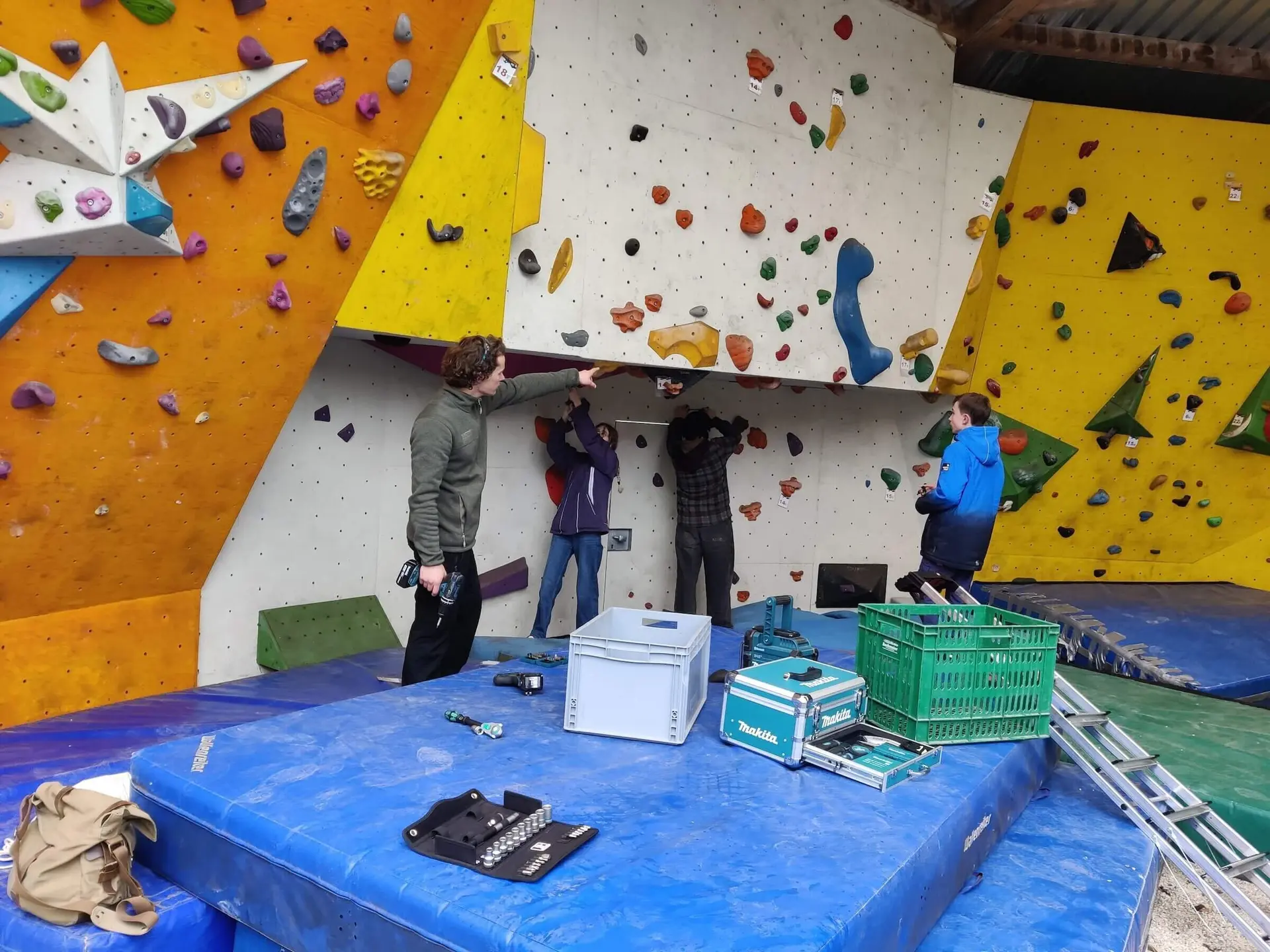 Vier Mitglieder reinigen den Bouldertempel, während sie Werkzeuge und Materialien im Einsatz haben. | © DAV Markt Schwaben