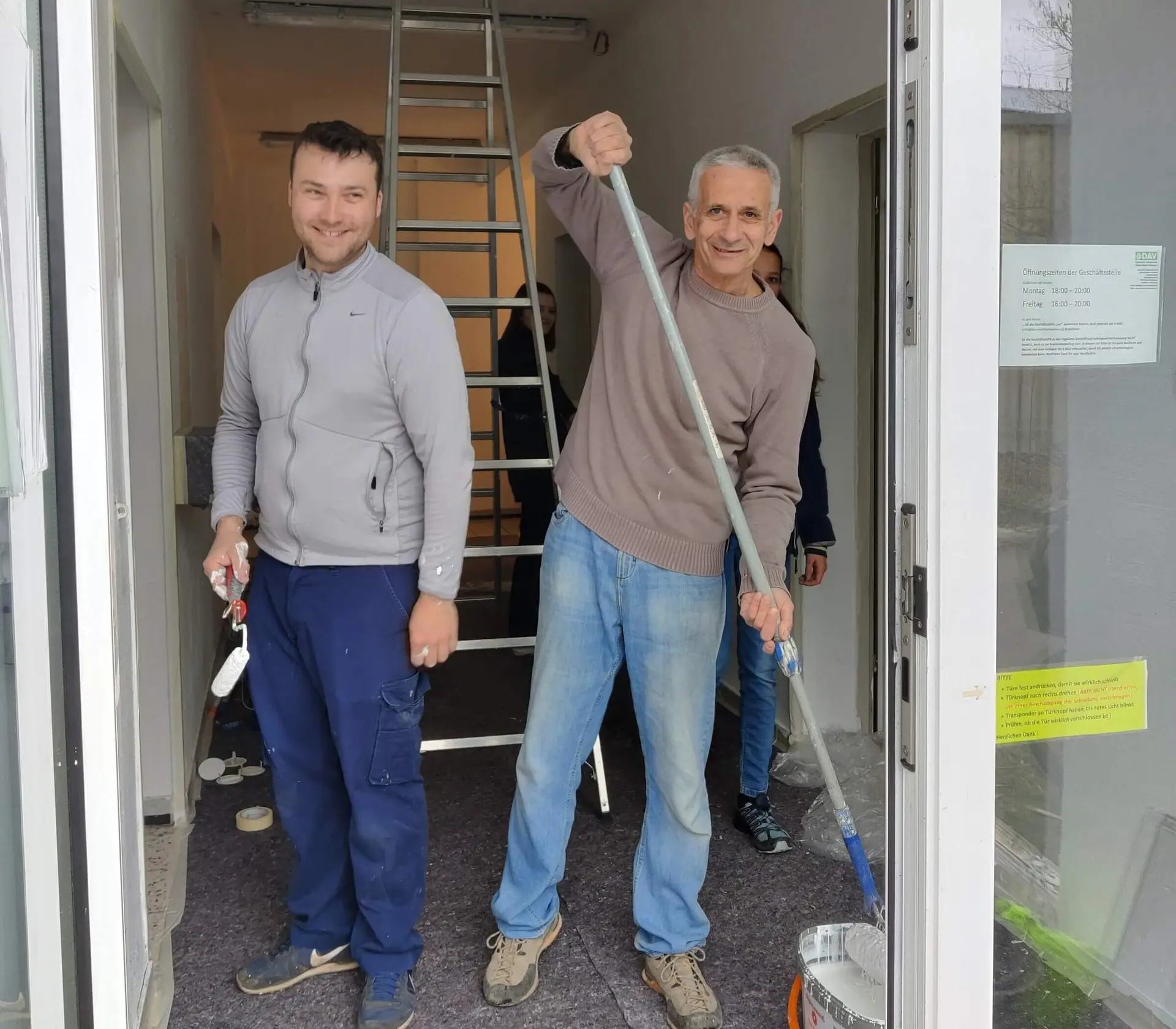 Zwei gut gelaunte Mitglieder streichen Heizkörper und Wände im Innenbereich während des Arbeitsdienstes. | © DAV Markt Schwaben