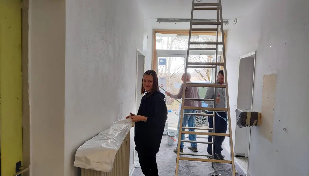 Ein Mitglied im Vordergrund, eine Leiter und zwei weitere Mitglieder, die den Flur während des Arbeitsdienstes im März 2025 streichen. | © DAV Markt Schwaben