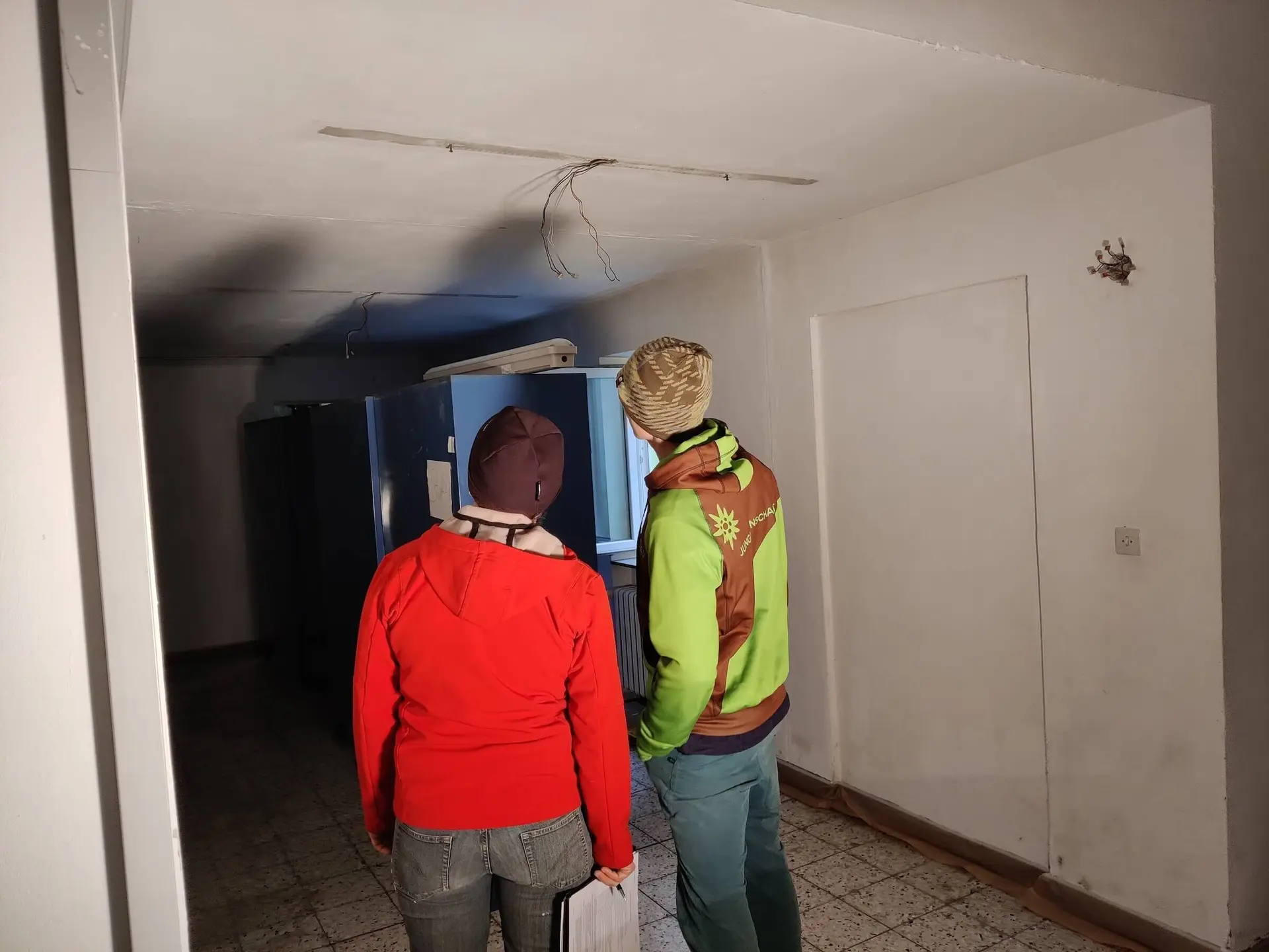 Zwei Mitglieder prüfen die Kletteranlagen im Flur, stehen mit dem Rücken zur Kamera und scheinen etwas zu besprechen. | © DAV Markt Schwaben