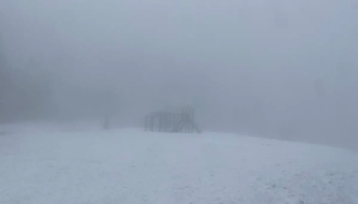 Spielplatzstruktur mit Rutsche und Kletterelementen, umgeben von Schnee und dichtem Nebel für eine mystische Atmosphäre. | © DAV Markt Schwaben