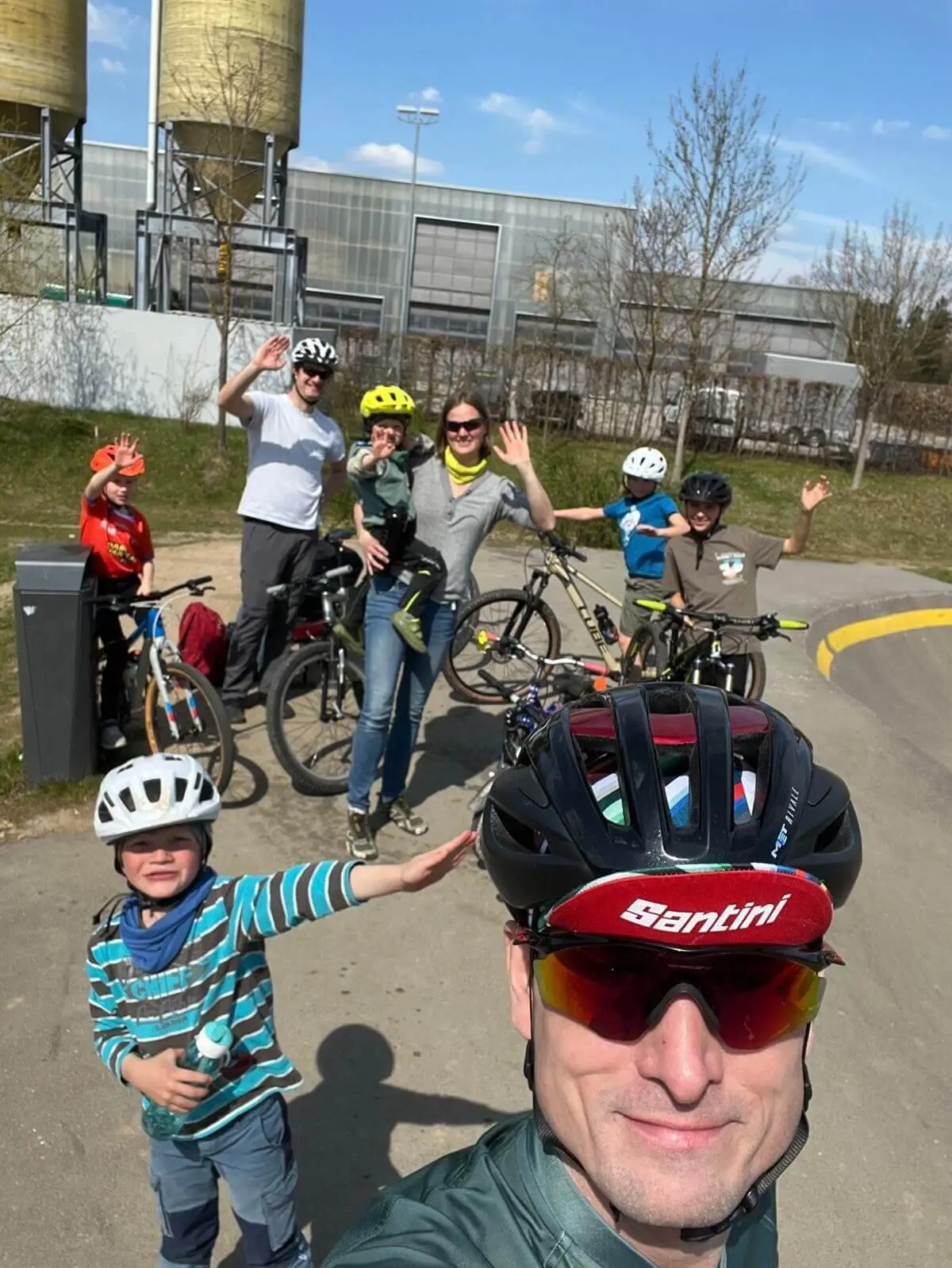 Kinder und Erwachsene trainieren auf dem Pumptrack, tragen Helme und winken fröhlich – Sicherheit & Teamgeist. | © DAV Markt Schwaben | Foto Miron Thoms