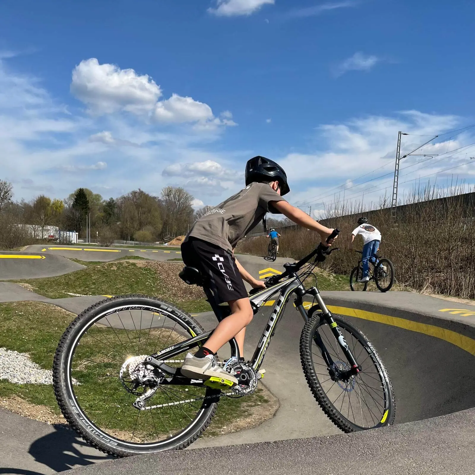 Biker auf BMX-Track mit Helm, meistern Kurven und Sprünge bei klarem Himmel – Action und Fahrspaß pur! | © DAV Markt Schwaben | Foto Miron Thoms