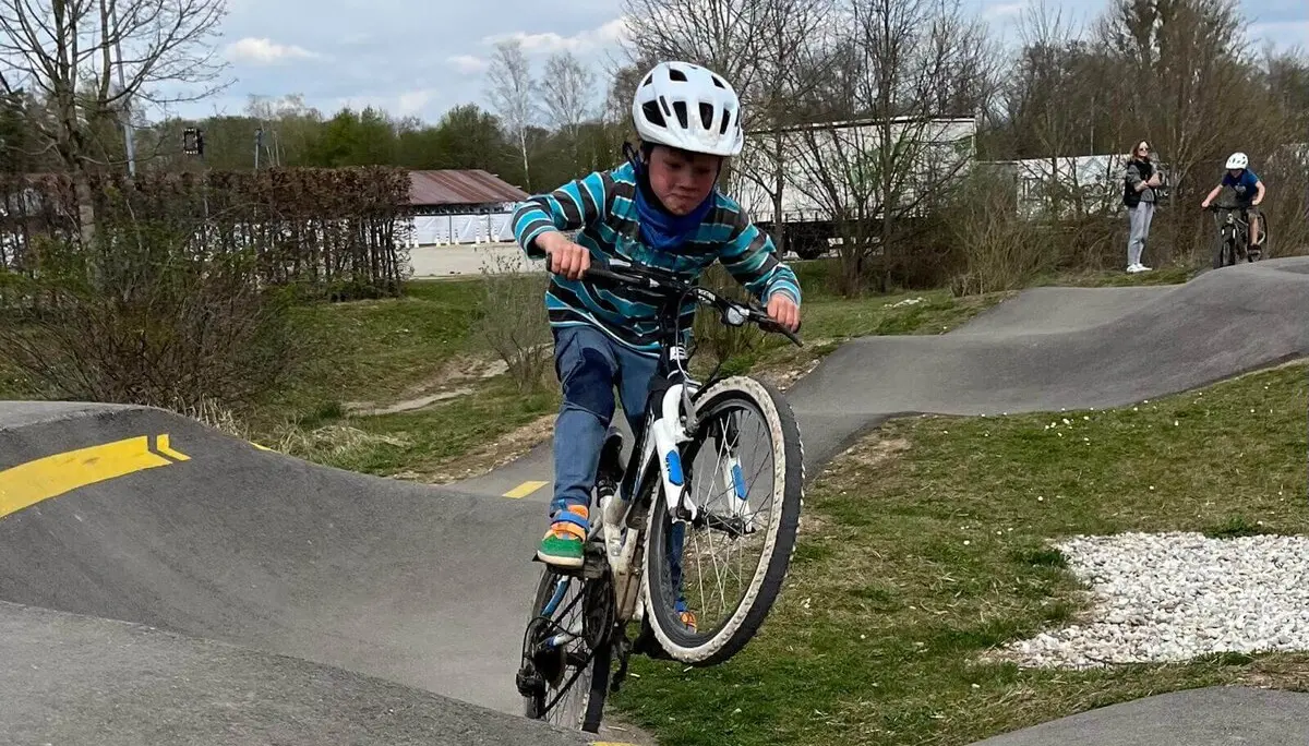 Radfahrer auf Pumptrack navigiert durch Kurven – Helm, Tempo und Techniktraining in dynamischer Bewegung. | © DAV Markt Schwaben | Foto Miron Thoms