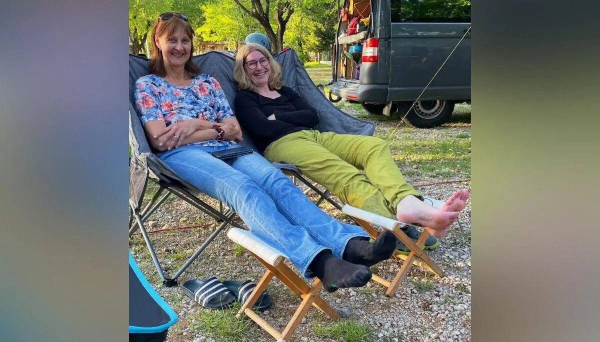 Zwei Personen entspannen in Liegestühlen vor einem offenen Campingbus; im Hintergrund Bäume und Ausrüstung. | © DAV Markt Schwaben | Foto Sebastian Gründel