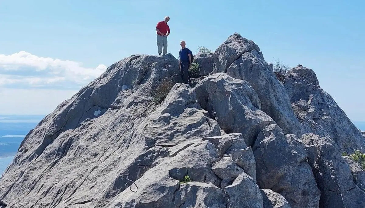 Zwei Personen stehen auf einem felsigen Gipfel mit Blick auf Meer und Inseln; klare Sicht und blauer Himmel. | © DAV Markt Schwaben | Foto Lutz Gründel