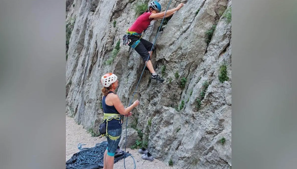 Eine Person klettert am Fels, die andere sichert vom Boden aus; Seil und Ausrüstung gut sichtbar. | © DAV Markt Schwaben | Foto Lutz Gründel