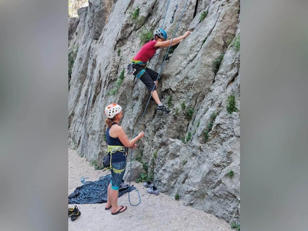 Eine Person klettert am Fels, die andere sichert vom Boden aus; Seil und Ausrüstung gut sichtbar. | © DAV Markt Schwaben | Foto Lutz Gründel