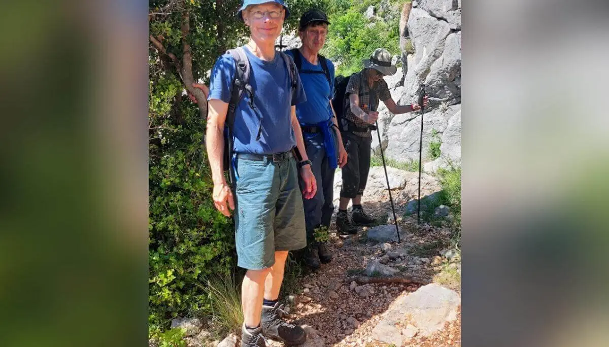 Drei Personen wandern durch felsiges Gelände; eine trägt blauen Hut, andere sind weiter hinten sichtbar. | © DAV Markt Schwaben | Foto Lutz Gründel