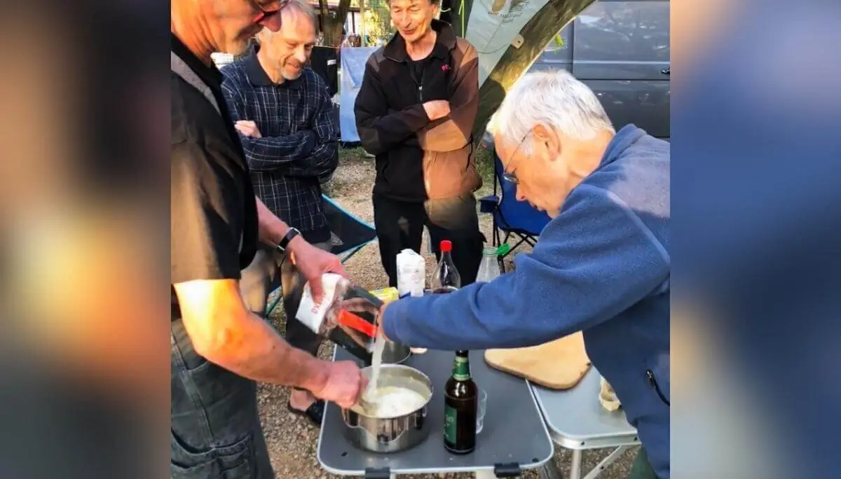 Vier Personen bereiten gemeinsam Essen am Campingtisch zu; Gewürze und Kochutensilien gut sichtbar. | © DAV Markt Schwaben | Foto Hildegard Petschik