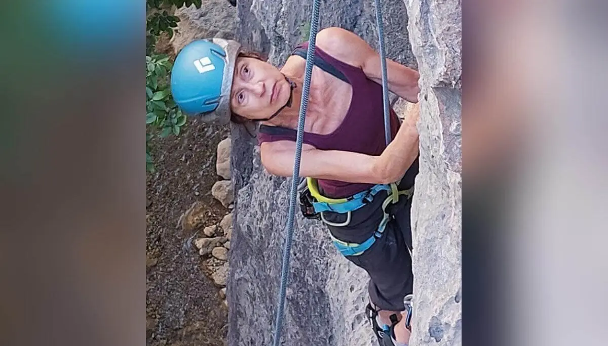 Eine Person mit blauem Helm klettert gesichert am Fels und schaut nach oben; Vegetation im Hintergrund. | © DAV Markt Schwaben | Foto Lutz Gründel