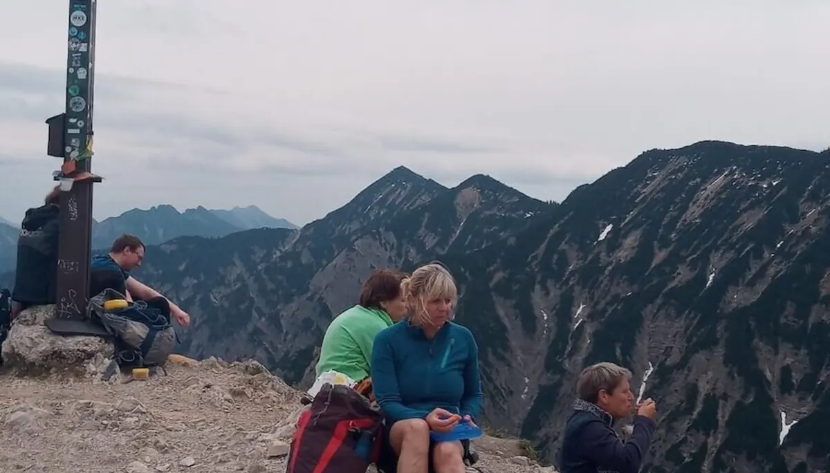 Ein Foto vom Gipfel mit Wanderern, die die atemberaubende Aussicht genießen. | © DAV Markt Schwaben | Foto Tanja Döhler