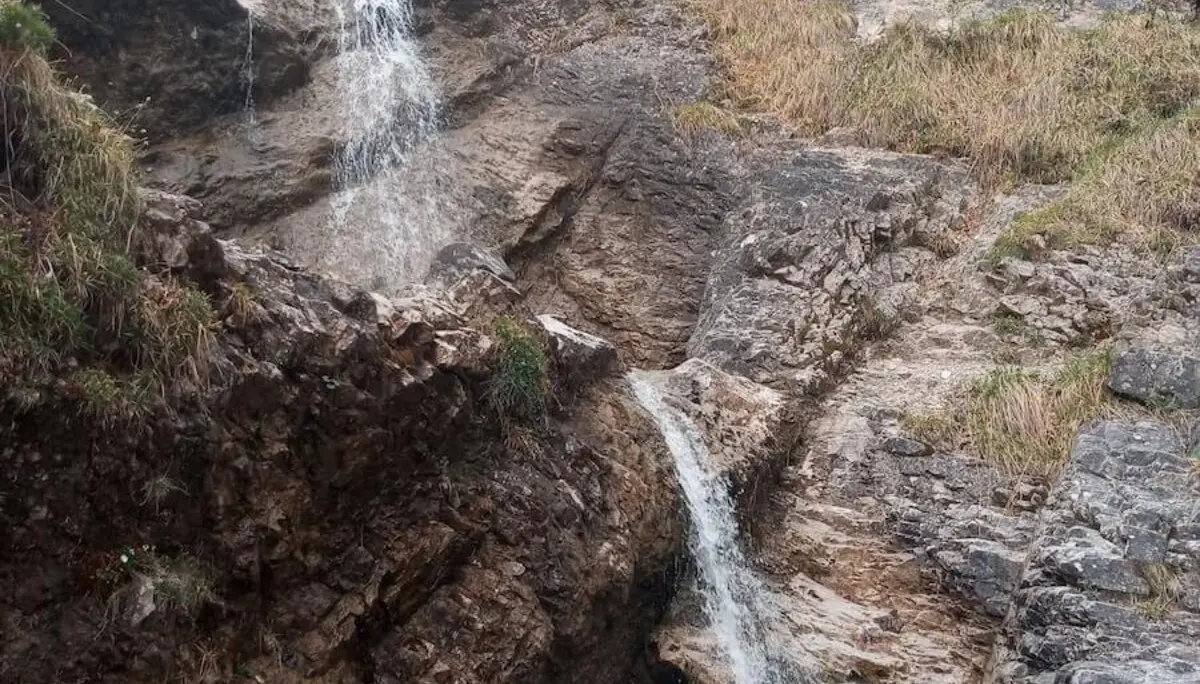 Ein friedliches Bild eines Wasserfalls, der inmitten der bewaldeten Umgebung über die Felsen hinabstürzt. | © DAV Markt Schwaben | Foto Tanja Döhler
