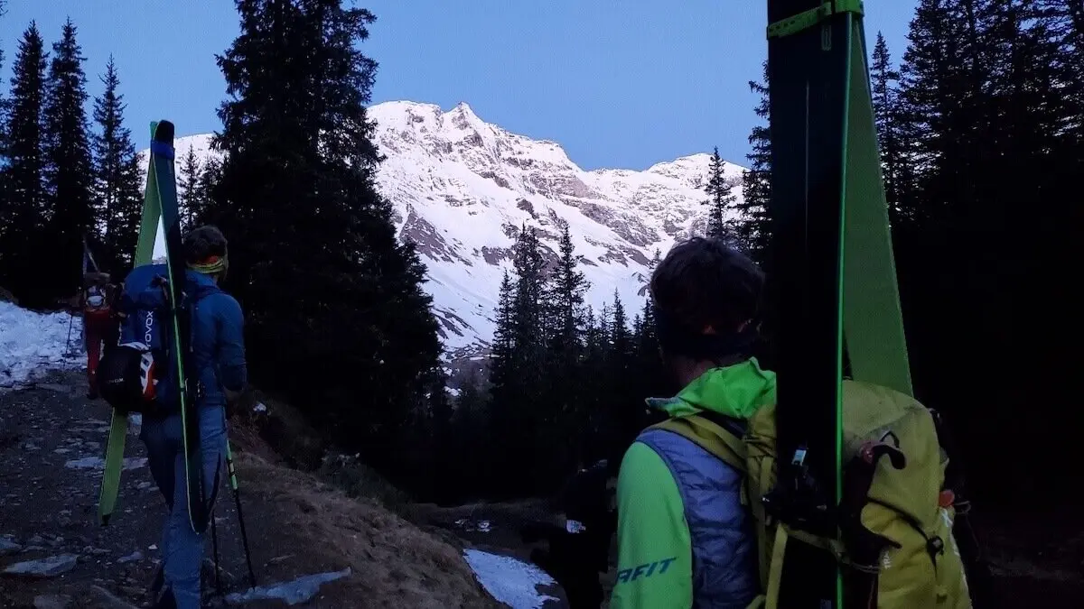 Drei Bergsteiger blicken im ersten Licht des Tages von einem verschneiten Hang zurück auf ihre Vortagestour | © DAV Markt Schwaben | Foto: Walter Kressirer