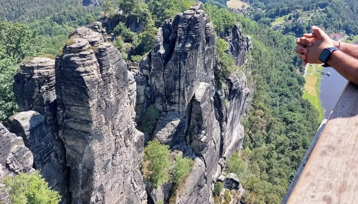 Person lehnt am Geländer, schaut auf steile Felsen und Flusstal, im Hintergrund bewaldete Hügel und Gebäude. | © DAV Markt Schwaben | Foto Lutz Gründel
