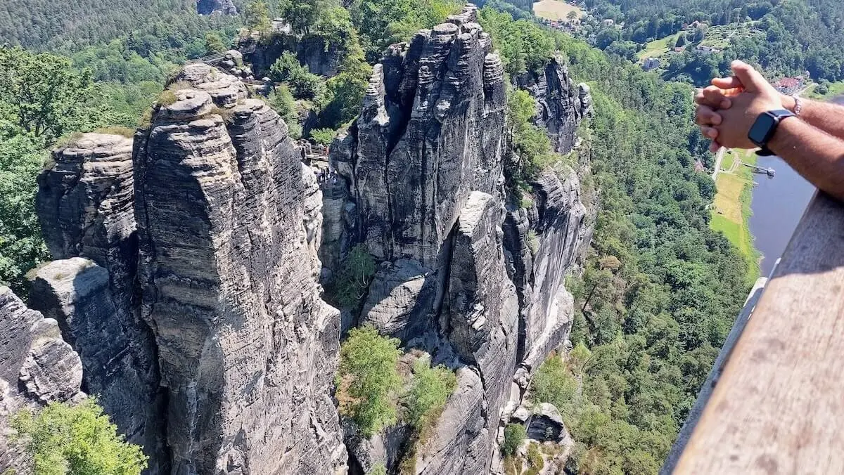 Person lehnt am Geländer, schaut auf steile Felsen und Flusstal, im Hintergrund bewaldete Hügel und Gebäude. | © DAV Markt Schwaben | Foto Lutz Gründel