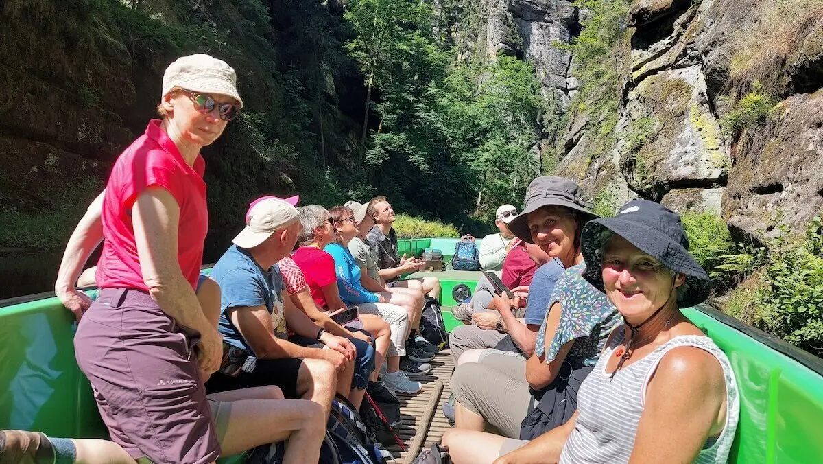 Gruppe sitzt im grünen Boot zwischen steilen Felswänden, umgeben von Wald, Licht fällt durch die Bäume. | © DAV Markt Schwaben | Foto Lutz Gründel