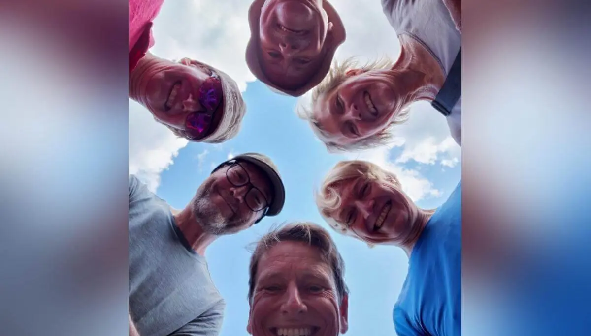Sechs Personen stehen im Kreis und blicken lachend in die Kamera; über ihnen blauer Himmel mit leichten Wolken. | © DAV Markt Schwaben | Foto Sabine Hainz