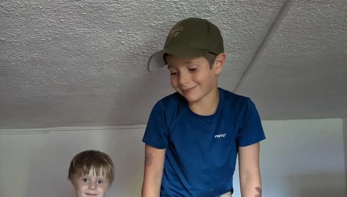 Zwei Kinder spielen lebhaft auf Etagenbetten in einer Berghütte. Einer balanciert über die obere Bettkante, der andere steht unten. | © DAV Markt Schwaben | Foto Familiengruppe