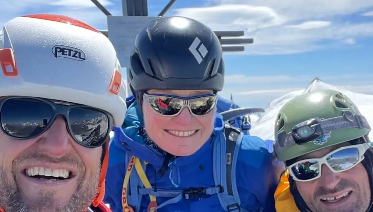 Drei Bergsteiger stehen vor einem Gipfelkreuz in den Westalpen – klare Sicht, Schnee und Kletterausrüstung zeigen den Moment des Erfolgs. | © DAV Markt Schwaben | Christian Reischl