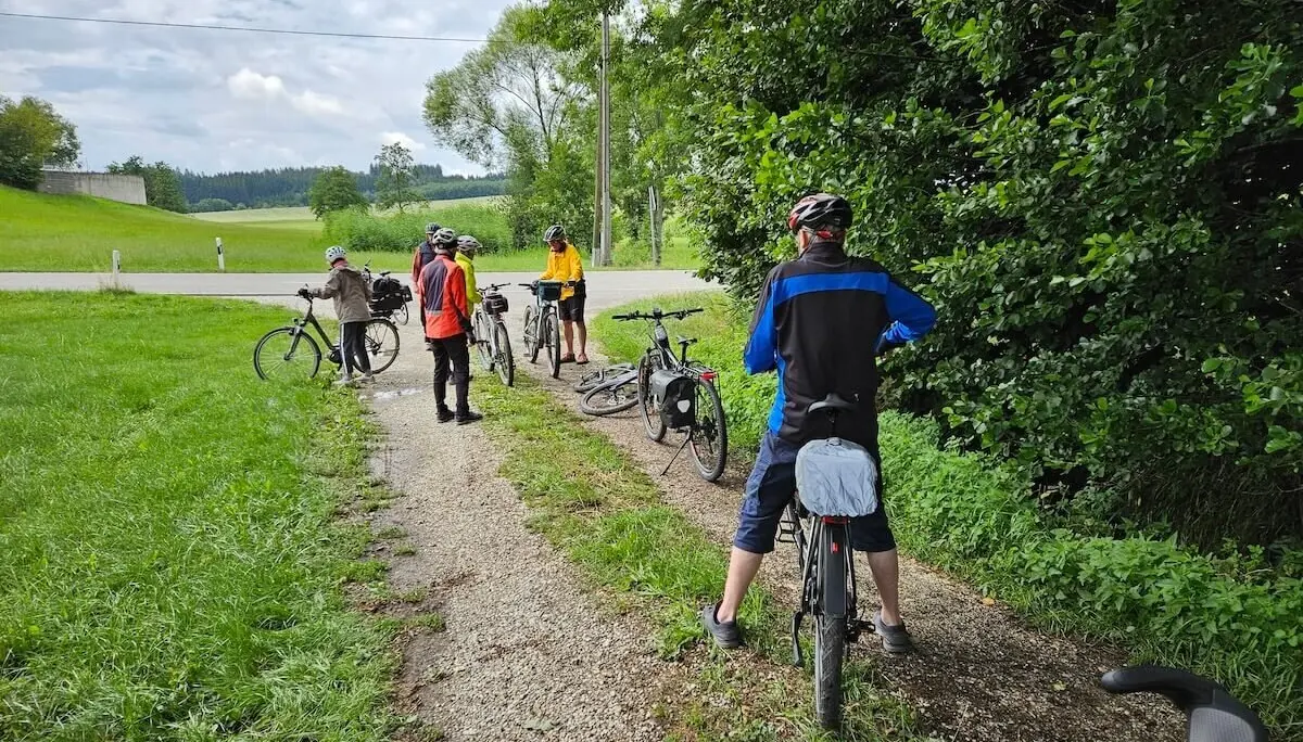 Sechs ältere Radfahrer machen Pause auf einem Landweg – Helme, Gepäcktaschen und Natur prägen das ländliche Tourenbild. | © DAV Markt Schwaben | Seniorengruppe