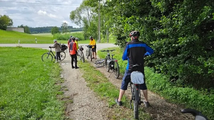Sechs ältere Radfahrer machen Pause auf einem Landweg – Helme, Gepäcktaschen und Natur prägen das ländliche Tourenbild. | © DAV Markt Schwaben | Seniorengruppe